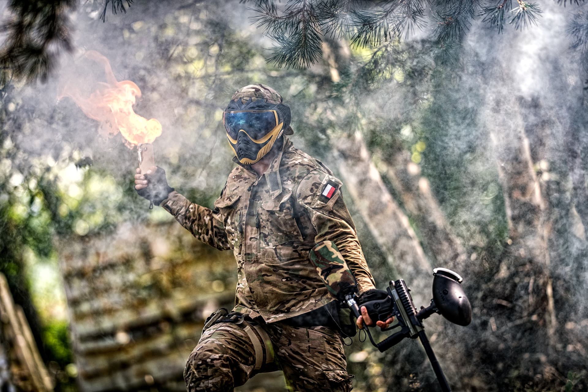 Gracz z racą i markerem w kłębach dymu na poligonie