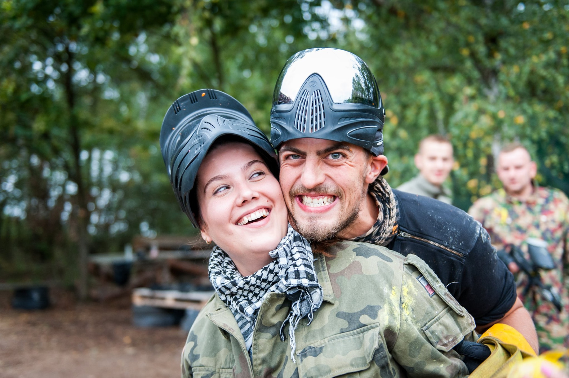 Uśmiechnięci gracze paintballowi w kombinezonach po grze